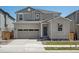 Charming two-story home with a brick facade, attached garage, and manicured lawn at 552 Red Rock Pl, Brighton, CO 80601