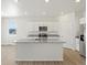 Bright kitchen with white cabinets, stainless appliances, and a large island with granite countertop at 552 Red Rock Pl, Brighton, CO 80601