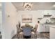 Elegant dining area featuring modern light fixture, stylish chairs, and gray laminate floors at 10211 Ura Ln # 7-204, Thornton, CO 80260
