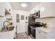 Charming kitchen with white cabinets, modern appliances, and stylish countertops for a fresh look at 10211 Ura Ln # 7-204, Thornton, CO 80260