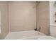 Close-up of tiled shower over tub with neutral colored tile at 10211 Ura Ln # 7-204, Thornton, CO 80260