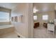 View of a Primary bathroom with a soaking tub, neutral tile, and a bedroom with natural light at 11918 S Hitching Post Trl, Parker, CO 80134