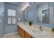 Light blue bathroom featuring dual sinks, framed mirrors and bright vanity lighting at 11918 S Hitching Post Trl, Parker, CO 80134