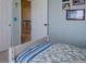 Bedroom showcasing a view of an open door, a bed with blue striped bedding, and bright interiors at 11918 S Hitching Post Trl, Parker, CO 80134