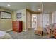 Bedroom featuring a wood dresser, comfortable seating and neutral decor, plus hall access at 11918 S Hitching Post Trl, Parker, CO 80134