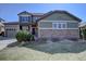Inviting two-story home with a three car garage, stone accents, and well-manicured landscaping at 11918 S Hitching Post Trl, Parker, CO 80134