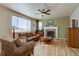 Cozy living room showcasing a ceiling fan, brick fireplace with white mantel, and lots of light at 11918 S Hitching Post Trl, Parker, CO 80134