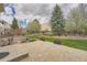 Beautiful backyard featuring stone patio, tiered garden, and mature trees at 18225 E Caley Dr, Aurora, CO 80016