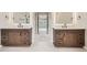 Modern bathroom with dual vanities, decorative mirrors, and view to an ensuite bath and walk-in closet at 18225 E Caley Dr, Aurora, CO 80016