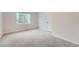 Bright bedroom featuring a large window, neutral carpeting, and a white painted door at 18225 E Caley Dr, Aurora, CO 80016