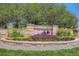 Decorative community entrance sign for The Farm, surrounded by colorful flower beds and mature trees at 18225 E Caley Dr, Aurora, CO 80016