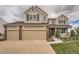Charming two-story home with a three-car garage, brick accents, and a well-manicured lawn at 18225 E Caley Dr, Aurora, CO 80016