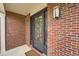 Elegant front door with intricate wrought iron detailing, set against a classic brick facade at 18225 E Caley Dr, Aurora, CO 80016
