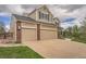 Spacious three-car garage, complemented by brick accents and a well-maintained lawn at 18225 E Caley Dr, Aurora, CO 80016
