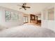 Bright living room with large windows, ceiling fan, and an open view of the gourmet kitchen at 18225 E Caley Dr, Aurora, CO 80016