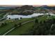Scenic aerial image highlights the lush golf course and tranquil lake views of this property at 6402 Wauconda Dr, Larkspur, CO 80118