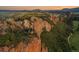 Stunning aerial view of a home nestled amongst rock outcroppings, lush greenery, and beautiful views of a golf course at 6402 Wauconda Dr, Larkspur, CO 80118