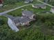 Aerial view of a beautiful home surrounded by green landscape, featuring a long driveway and spacious backyard at 6402 Wauconda Dr, Larkspur, CO 80118