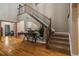 Welcoming foyer featuring a staircase with iron railing and hardwood floors leading to other living spaces at 6402 Wauconda Dr, Larkspur, CO 80118