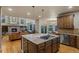 Open kitchen with hardwood floors, a central island, and views into the living room at 6402 Wauconda Dr, Larkspur, CO 80118