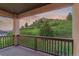 Balcony with railings overlooking landscaped yard and a picturesque view of the mountains in the distance at 6402 Wauconda Dr, Larkspur, CO 80118