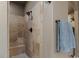 Close up of a tile shower with a built-in bench, black fixtures, and neutral stone tiling at 6402 Wauconda Dr, Larkspur, CO 80118