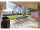 Spacious covered patio with a long table and chairs surrounded by a lush lawn and mature trees at 2 Larkdale Dr, Littleton, CO 80123