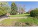 Spacious backyard with mature trees, a lush lawn, and well-maintained landscaping at 2 Larkdale Dr, Littleton, CO 80123