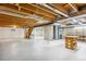 Unfinished basement with exposed wooden beams and concrete columns ready for customization at 2 Larkdale Dr, Littleton, CO 80123