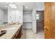 Bright bathroom featuring a granite vanity, walk-in closet, and accessible walk-in shower at 2 Larkdale Dr, Littleton, CO 80123