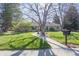 Charming brick home with a well-manicured lawn, mature trees and a welcoming walkway to the front door at 2 Larkdale Dr, Littleton, CO 80123