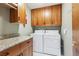 Functional laundry room with cabinetry, granite counters, and modern washer and dryer at 2 Larkdale Dr, Littleton, CO 80123