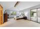 Spacious main bedroom features an exposed beam, a large window, and sliding glass door to the patio at 2 Larkdale Dr, Littleton, CO 80123
