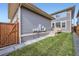Backyard featuring a small lawn, a fence, and a home with stairs to a deck at 5983 Fulton St, Denver, CO 80238