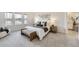 Light-filled bedroom boasts neutral decor, a king bed with bench, and natural light from the windows at 5983 Fulton St, Denver, CO 80238