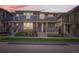 Inviting two-story townhome with brick accents, covered porch, and manicured lawn at 5983 Fulton St, Denver, CO 80238