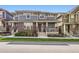 Inviting two-story townhome with brick accents, covered porch, and manicured lawn at 5983 Fulton St, Denver, CO 80238