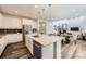 Open kitchen and dining area with island, seating, and stainless steel appliances at 5983 Fulton St, Denver, CO 80238