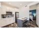Cozy kitchenette includes stainless appliances, gray backsplash, and an eat-in island at 5983 Fulton St, Denver, CO 80238