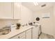Well-organized laundry room with modern washer and dryer, sink and lots of storage at 5983 Fulton St, Denver, CO 80238