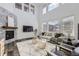 Modern living room with stone fireplace, high ceilings, and large windows at 5983 Fulton St, Denver, CO 80238