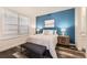 Comfortable main bedroom featuring a blue accent wall and modern furnishings at 5983 Fulton St, Denver, CO 80238