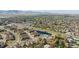 An aerial view of a community with a pond and highway access surrounded by green spaces and distant mountain views at 6378 Noble Ct, Arvada, CO 80403