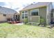 Green backyard with a small deck, flower beds, and ample space for outdoor activities at 6378 Noble Ct, Arvada, CO 80403
