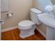 Powder bathroom with hardwood flooring, pedestal sink, and bright fixtures at 6378 Noble Ct, Arvada, CO 80403