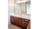 Bathroom vanity with wood cabinets, a white countertop, and a large mirror above the sink at 6378 Noble Ct, Arvada, CO 80403