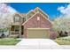 Inviting two-story home featuring a brick facade, covered porch, and well-maintained lawn at 6378 Noble Ct, Arvada, CO 80403
