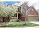 Charming two-story home with lush lawn, flowering trees, covered porch and brick accents at 6378 Noble Ct, Arvada, CO 80403