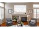 Cozy living room with fireplace, plush armchairs, and bright natural light at 6378 Noble Ct, Arvada, CO 80403