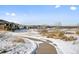 Snow-covered path winds through a residential community with mountain views at 6891 Longpark Dr, Parker, CO 80138